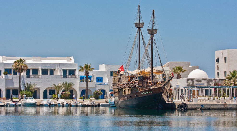 Im Hafen von Sousse finden wir Vielerlei. Auch in Tunesien liegen im Hafen die typischen Motorboote und Yachten vor Anker. Einige Einheimische haben hier auch noch ihre kleinen und sehr farbenfrohen Boote vertäut. Doch besonders auffällig ist uns das Piratenschiff, das hier vor Anker liegt. Es ist ein Zweimaster, der per Zeitmaschine aus einem frühen Jahrhundert den Weg hierher gefunden haben könnte. Er lädt uns ein, an Bord zu gehen. Das Glückshotel Tunesien zu buchen, war eine gute Idee. Es hat uns auf die erste Seite eines wundervollen Märchenbuchs geführt. (#1)